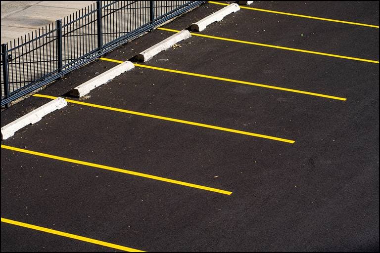 Freshly striped parking lot in Mobile, Alabama — crisp yellow stall lines on new black asphalt
